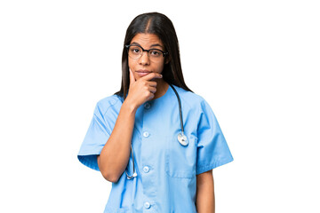Young African american nurse woman over isolated background having doubts and with confuse face...