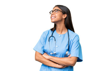 Young African american nurse woman over isolated background looking up while smiling