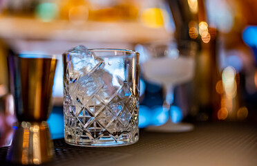 Ice cube in an empty glass on a bar counter in bar or pub