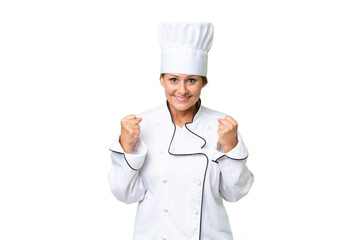 Middle-aged chef woman over isolated background celebrating a victory in winner position