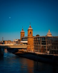 Fototapeta na wymiar Cannon Street Railway Bridge in London and the full moon in the blue sky