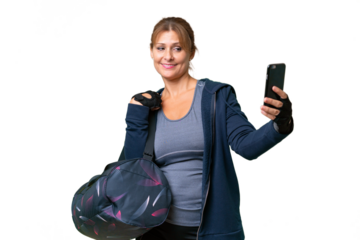 Middle-aged sport woman with sport bag over isolated background making a selfie