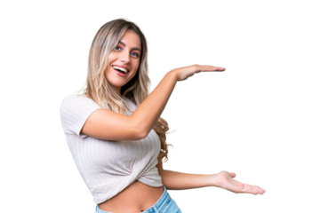 Young Uruguayan woman over isolated background holding copyspace to insert an ad