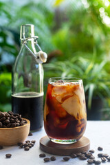 A glass of homemade cold brew coffee with milk on bright green background