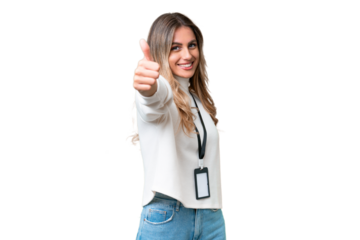Young Uruguayan woman with ID card over isolated background with thumbs up because something good has happened