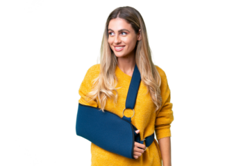 Young Uruguayan woman with broken arm and wearing a sling over isolated background looking side