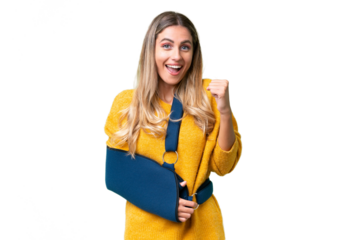 Young Uruguayan woman with broken arm and wearing a sling over isolated background celebrating a victory in winner position