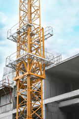 Construction site with tower crane near unfinished building