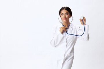 Woman doctor with stethoscope in hand in medical gown on white nurse background, consequences of...
