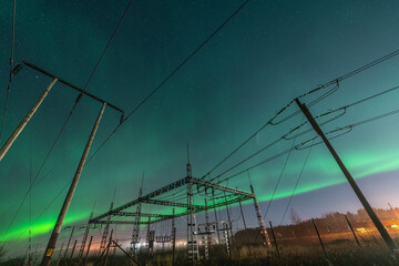 Beautiful night Aurora over electrical substation and wooden pole power lines, side view, starry...