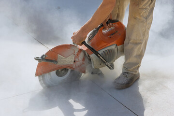 Diamond blade saws are used by construction workers to cut concrete sidewalk
