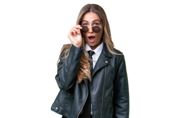 Business pretty Uruguayan woman wearing a biker jacket over isolated background with glasses and surprised