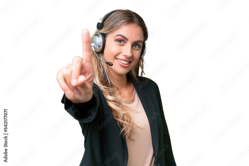 Wall mural Telemarketer pretty Uruguayan woman working with a headset over isolated background showing and lifting a finger