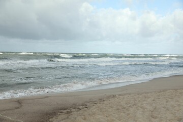 Picturesque view of wavy sea on cloudy day