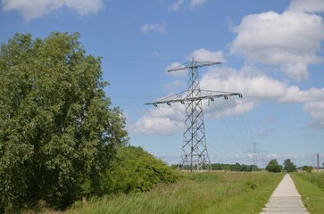 Modern high voltage towers in field on sunny day