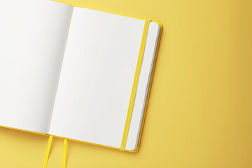 Blank notebook on pale yellow background, top view. Space for text