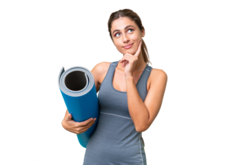 Pretty Young Uruguayan sport woman going to yoga classes while holding a mat over isolated background thinking an idea while looking up