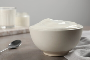 Bowl with delicious organic yogurt on grey table, closeup
