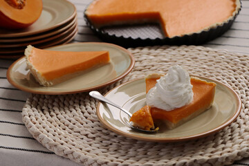 Fresh homemade pumpkin pie with whipped cream on table