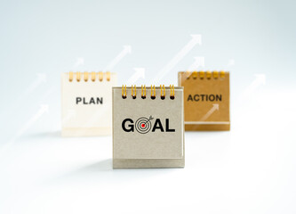 Business action, plan and goal, text and icons on small grey, beige and white desk calendar year 2023 standing with rise up arrows on white background. Strategy to success concept, minimal style.