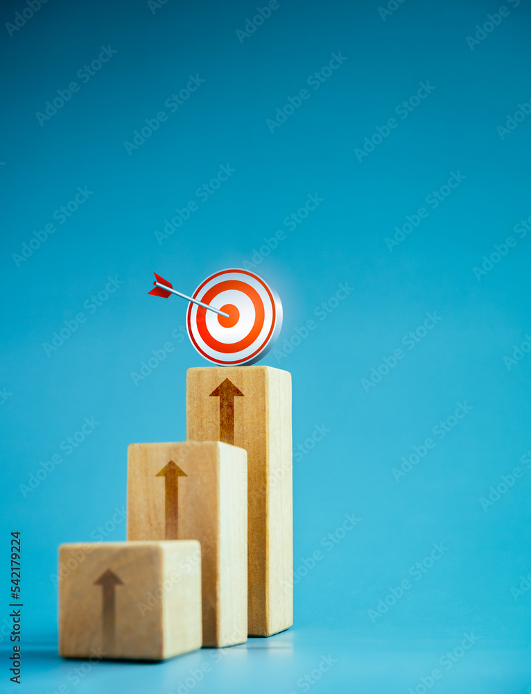 Poster target icon on top of wooden blocks with rise up arrows, 3d bar graph chart steps on blue background