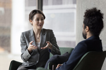 Dialogue of multi ethnic businesspeople in office, attractive millennial businesswoman talk to...