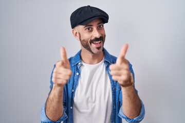Hispanic man with beard standing over isolated background pointing fingers to camera with happy and funny face. good energy and vibes.