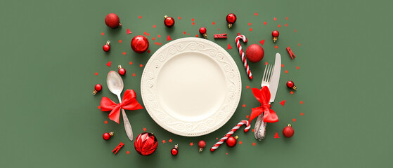 Beautiful table setting with Christmas decorations on green background
