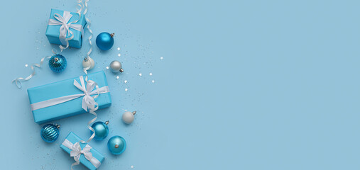 Composition with Christmas gifts, balls and decor on light blue background with space for text