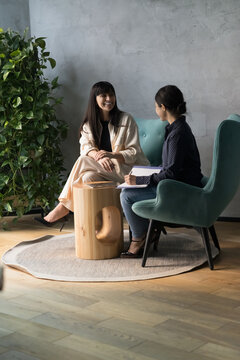 Multi ethnic businesswomen talking meet in modern workspace, Indian female apprentice writing helpful information, listens to middle-aged mentor company boss, coach. Advices, mentoring, interview