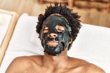 Young african american man having skin face treatment at beauty center