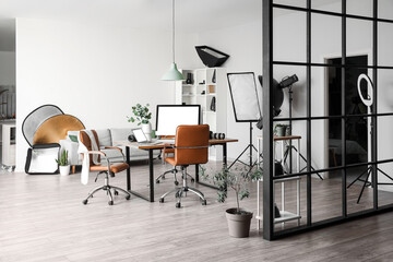 Interior of modern office with photographer's workplace and professional equipment