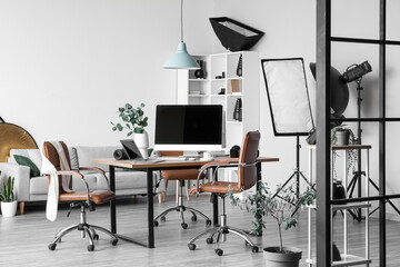 Interior of modern studio with photographer's workplace and professional equipment