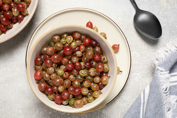 Many fresh ripe gooseberries on light table, flat lay