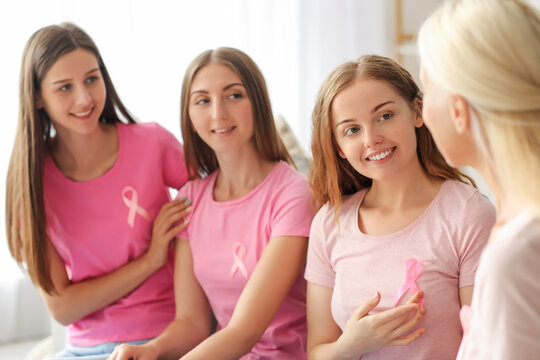 Beautiful women with pink awareness ribbons at home. Breast cancer concept