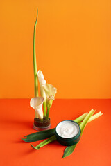 Jar of cream with beautiful ikebana on red background