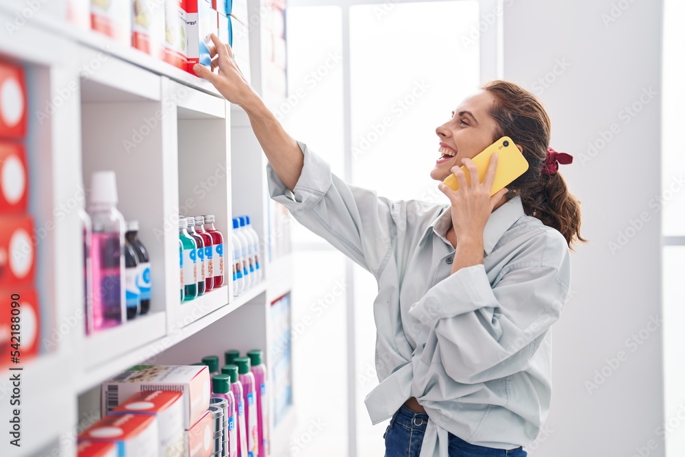 Poster young woman customer talking on smartphone at pharmacy