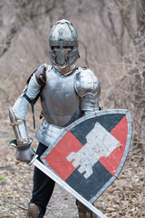 Noble warrior. Portrait of one medeival warrior or knight in armor and helmet with shield and sword posing