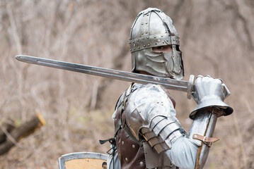 Noble warrior. Portrait of one medeival warrior or knight in armor and helmet with shield and sword...