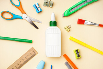 Composition with bottle of glue and different stationery on color background