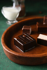 Plate with tasty bird's milk candies on color background, closeup