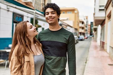 Young interracial couple smiling happy and hugging standing at the city.