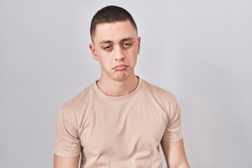 Young man standing over isolated background depressed and worry for distress, crying angry and afraid. sad expression.