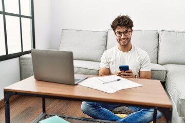 Young hispanic man smiling confident working at home