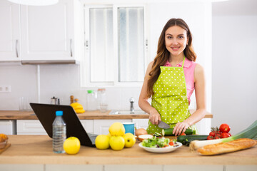 Obraz na płótnie Canvas Woman cooking salad recipe from the Internet