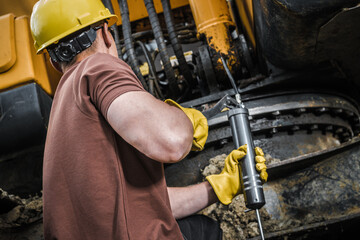 Construction Worker Performing Excavator Maintenance