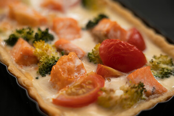 Ready-made quiche with salmon, broccoli and tomatoes. Cooking a pie.