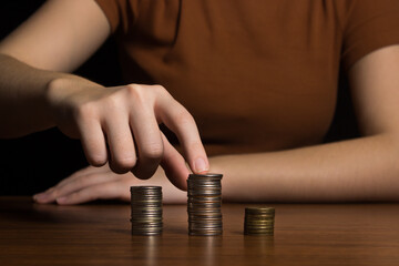 Woman's hand chooses a stack of coins on a black background. interest rate and dividend concept....
