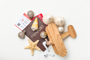 Passport with earphones, wooden airplane and Christmas decor on white background