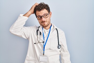 Young hispanic man wearing doctor uniform and stethoscope confuse and wonder about question. uncertain with doubt, thinking with hand on head. pensive concept.